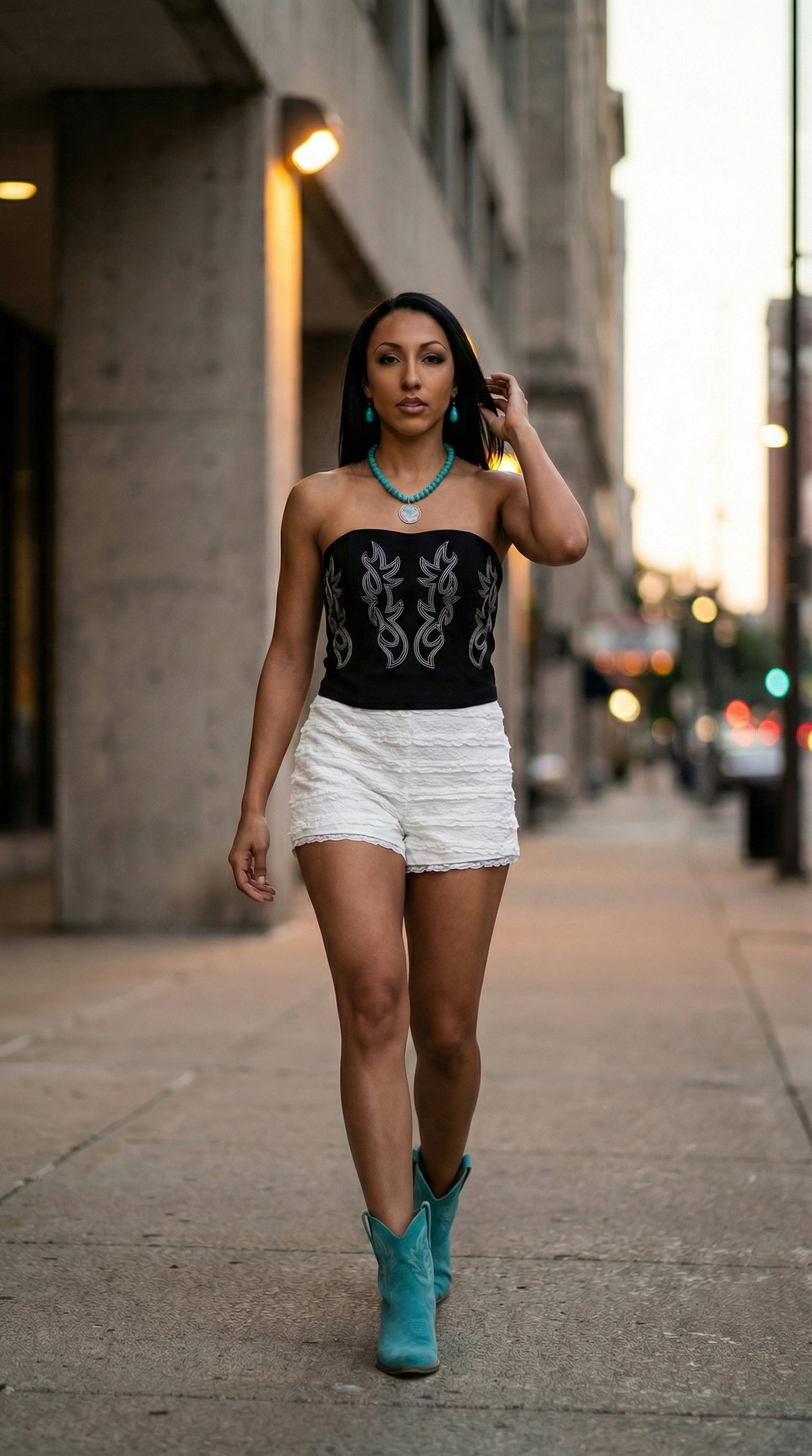 Model wearing a black embroidered velvet corset with white lace ruffle shorts.