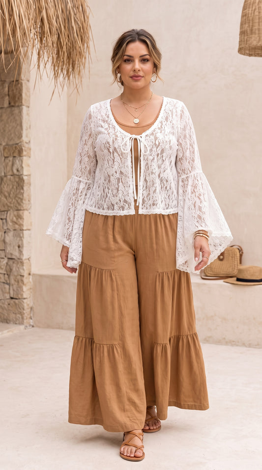 Model wearing an ivory lace tie-front top with bell sleeves over brown palazzo pants.